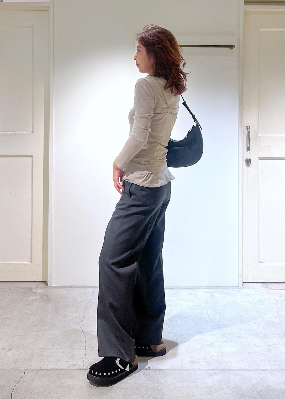 ブラック系のショルダーバッグ、グレー系のスラックス、ゴールド系のTシャツ/カットソーを着用したレディースの秋コーディネートの4枚目の写真