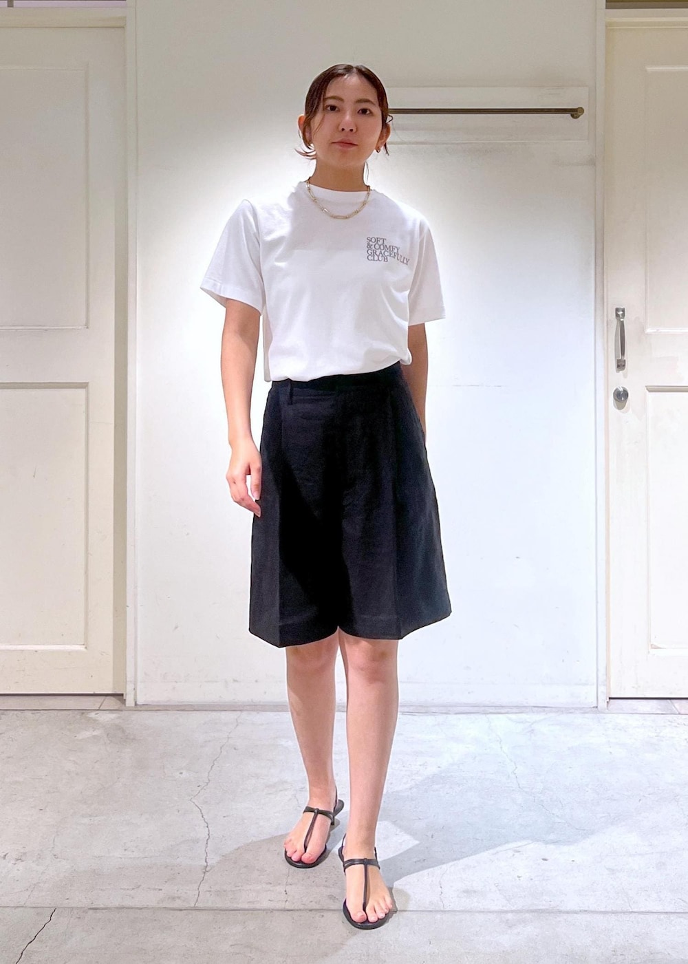 ブラック系のサンダル、ホワイト系のTシャツ/カットソー、ベージュ系のかごバッグを着用したレディースの春コーディネートの5枚目の写真