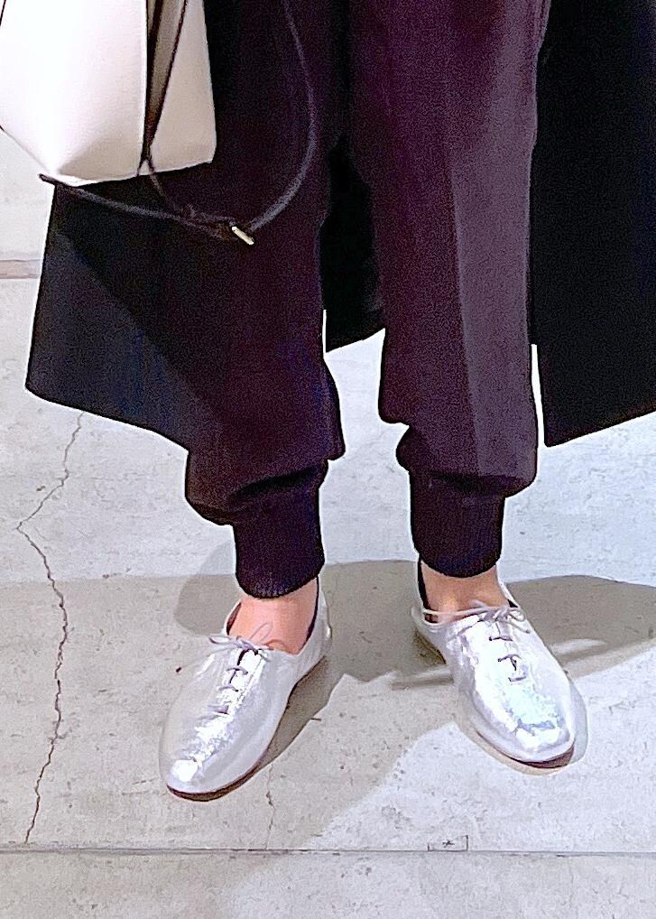 シルバー系のその他シューズ、ブラック系のジャンパースカート、グレー系のその他パンツを着用したレディースの春コーディネートの6枚目の写真