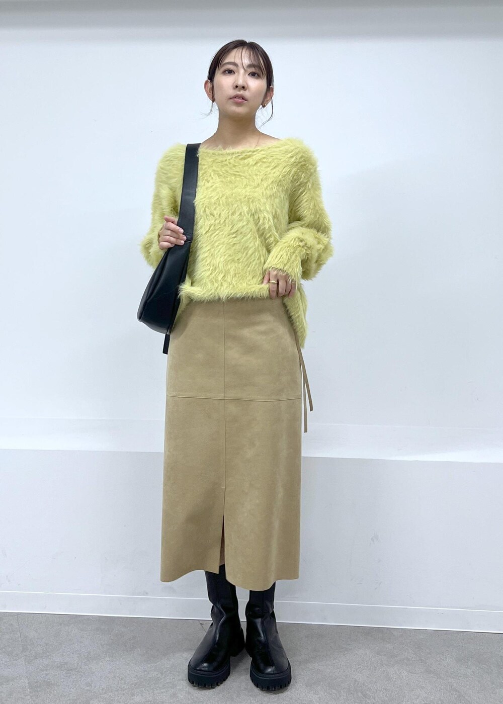 ブラック系のショルダーバッグ、ブラック系のブーツ、ベージュ系のスカートを着用したレディースの秋コーディネートの4枚目の写真