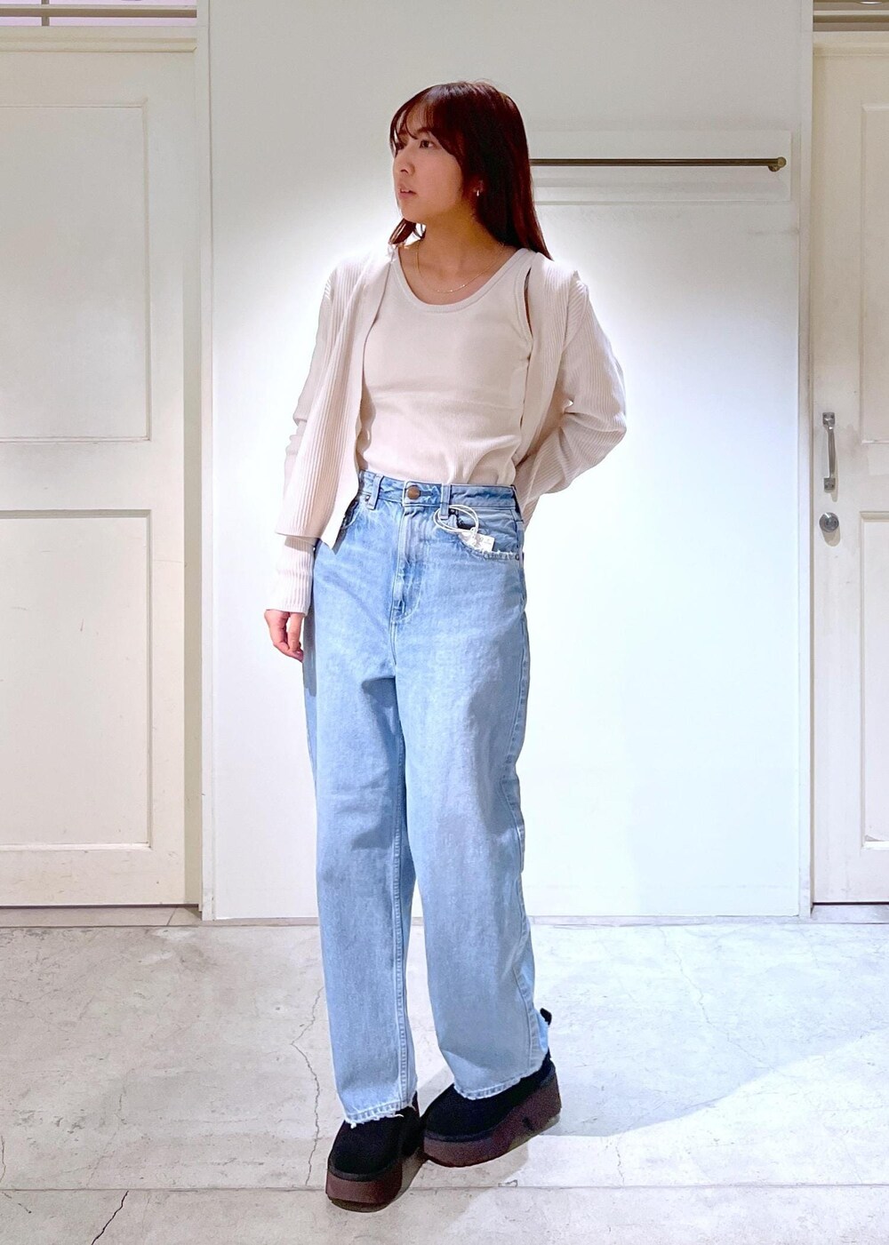 ブラック系のブーツ、ホワイト系のタンクトップ、ブラック系のハンドバッグを着用したレディースの冬コーディネートの4枚目の写真