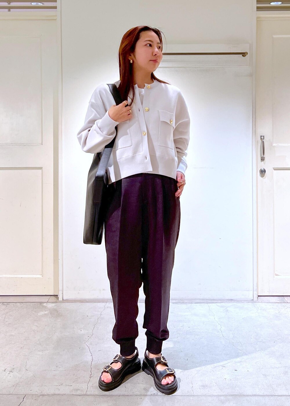 グレー系のその他パンツ、ブラック系のショルダーバッグ、ホワイト系のTシャツ/カットソーを着用したレディースの春コーディネートの4枚目の写真