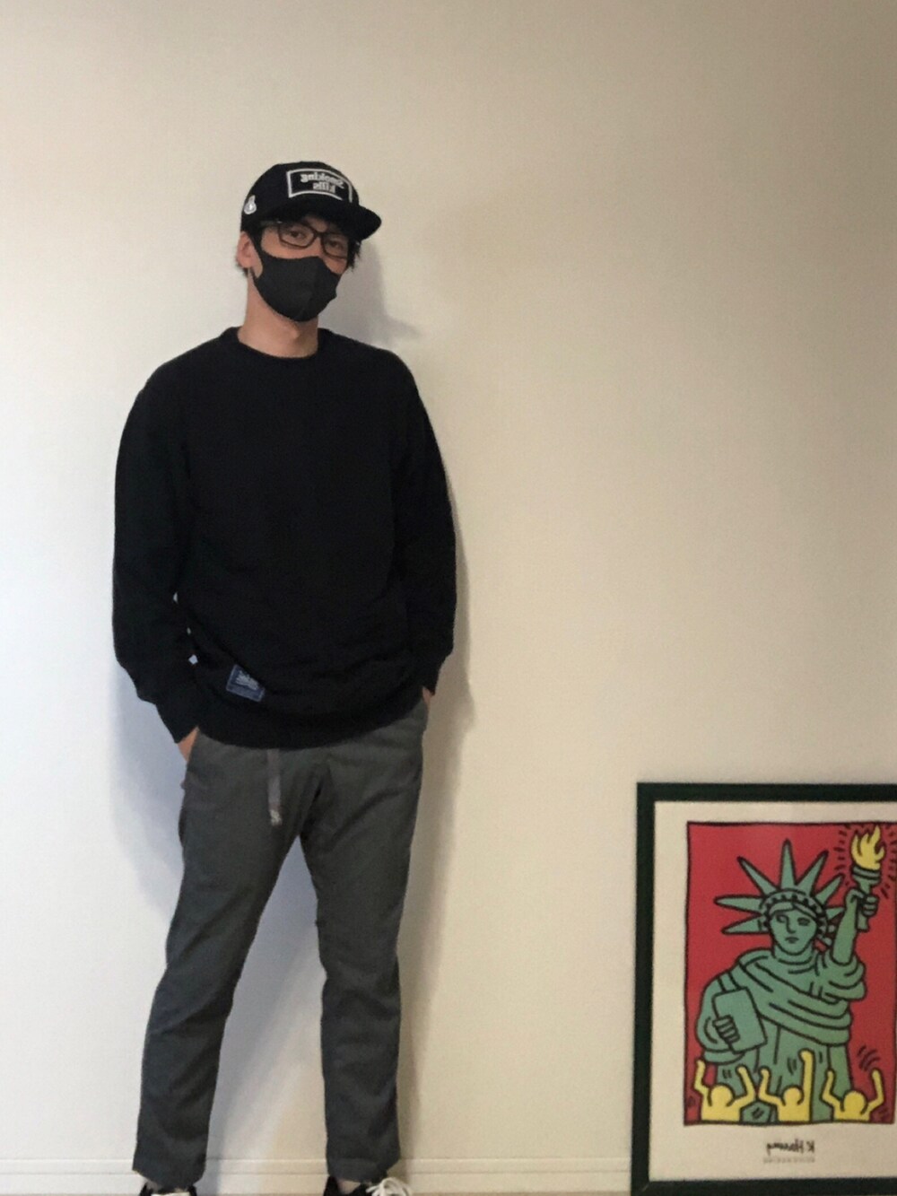 ブラック系のパーカー、グレー系のスラックス、ブラック系のスニーカーを着用したメンズの春コーディネートの3枚目の写真