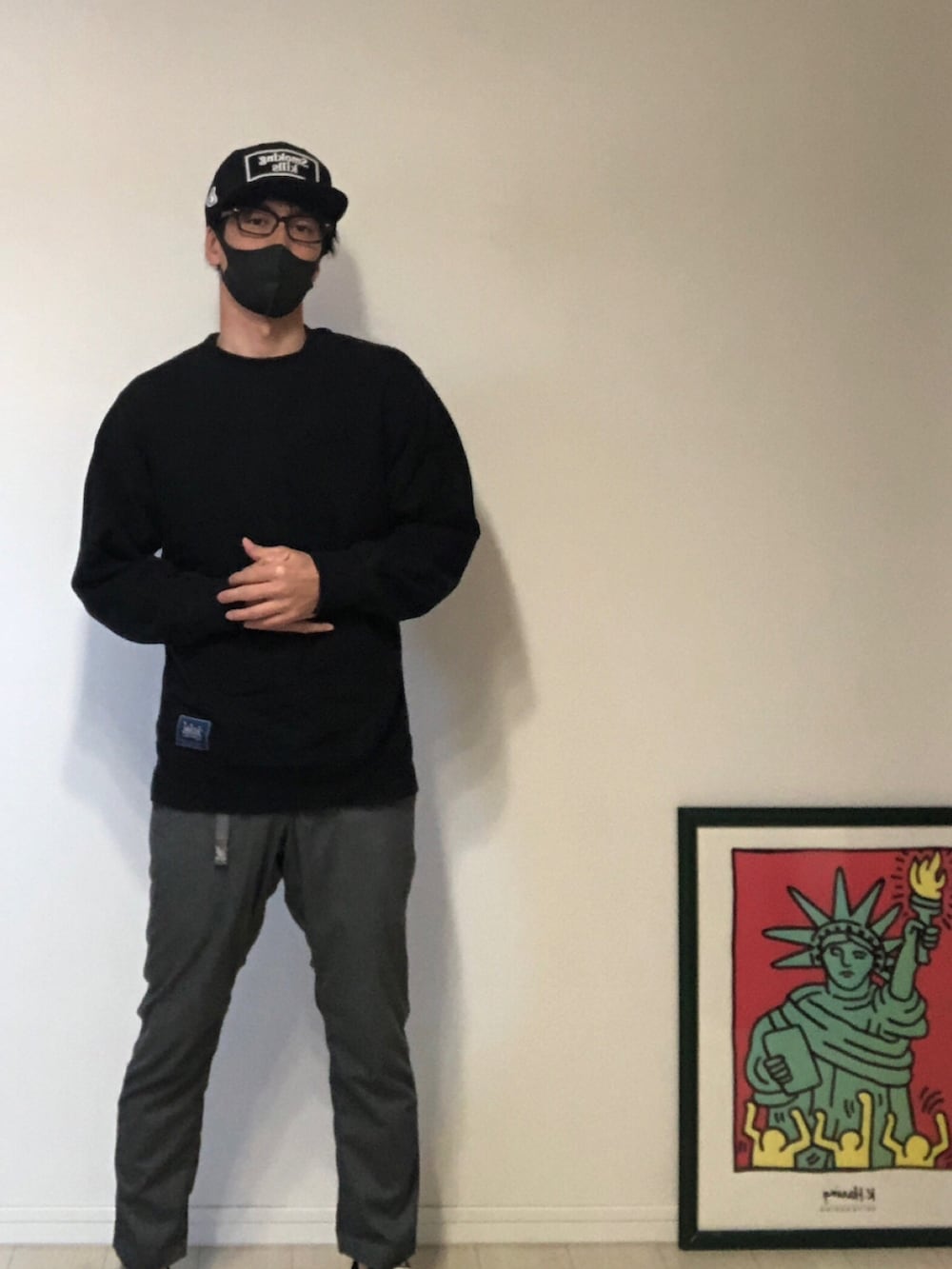 ブラック系のパーカー、グレー系のスラックス、ブラック系のスニーカーを着用したメンズの春コーディネートの2枚目の写真