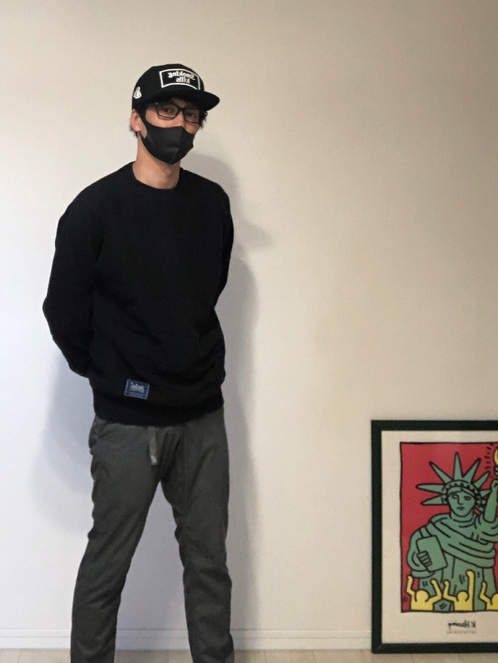 ブラック系のパーカー、グレー系のスラックス、ブラック系のスニーカーを着用したメンズの春コーディネートの4枚目の写真