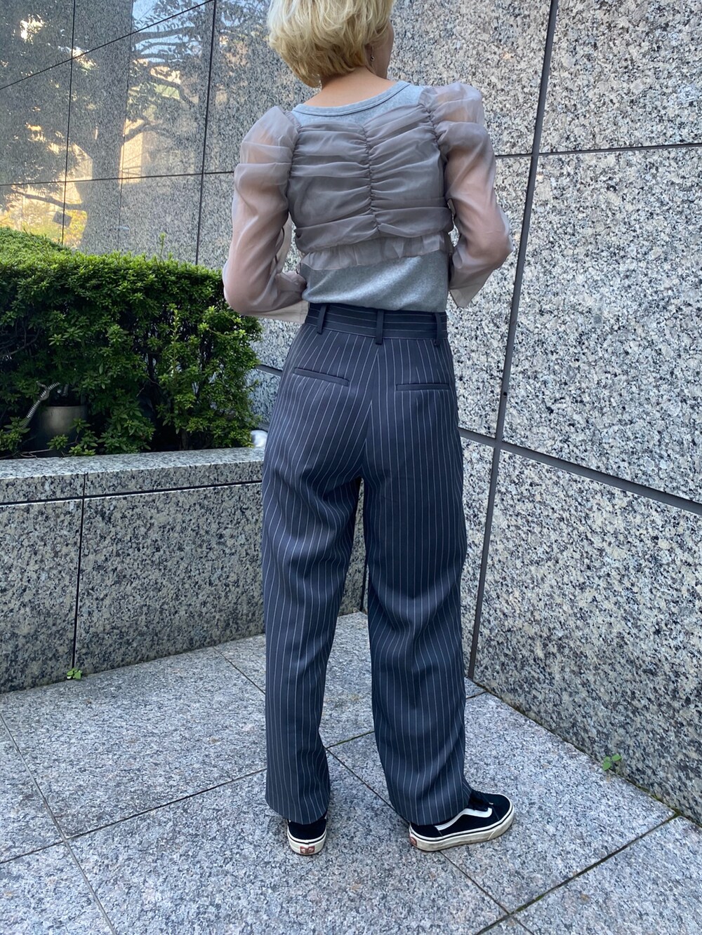 レッド系のパンツを着用したレディースの秋コーディネートの2枚目の写真