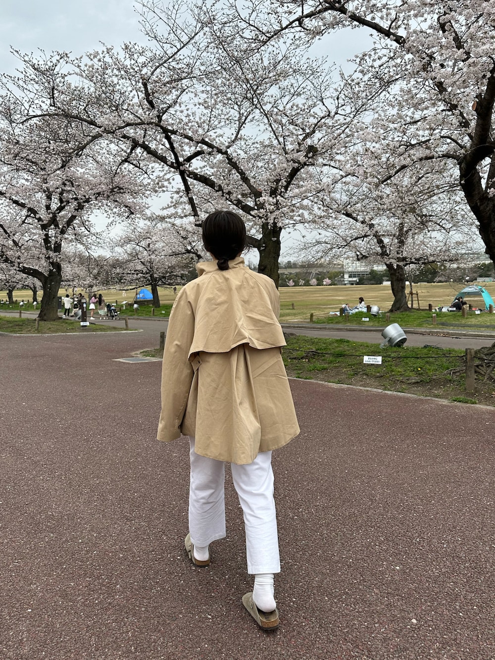 ベージュ系のトレンチコート、ホワイト系のその他パンツを着用したレディースの春コーディネートの3枚目の写真
