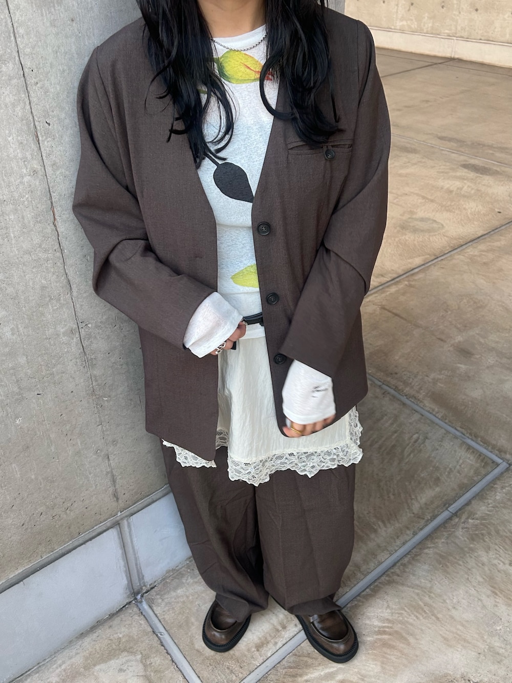 ブラウン系のノーカラージャケット、ブラウン系のその他パンツ、ホワイト系のキャミソールを着用したレディースの冬コーディネートの4枚目の写真