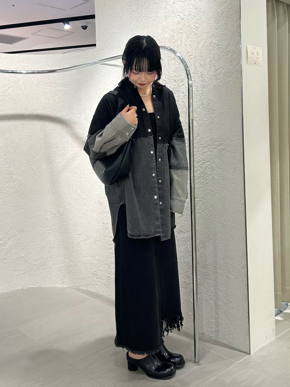 グレー系のシャツ/ブラウス、ブラック系のスカート、ブラック系のサンダルを着用したレディースの冬コーディネートの2枚目の写真