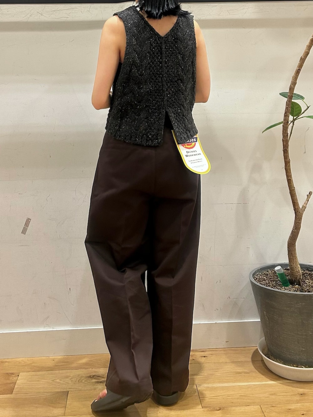 グレー系のニット/セーター、ブラウン系のチノパンツを着用したレディースの秋コーディネートの2枚目の写真