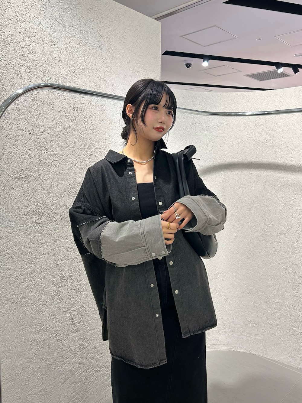 グレー系のシャツ/ブラウス、ブラック系のスカート、ブラック系のサンダルを着用したレディースの冬コーディネートの3枚目の写真