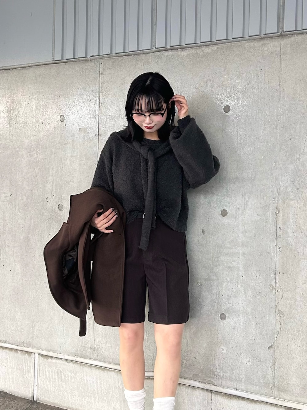 グレー系のニット/セーター、ブラウン系のその他パンツ、ブラック系のスニーカーを着用したレディースの秋コーディネートの2枚目の写真