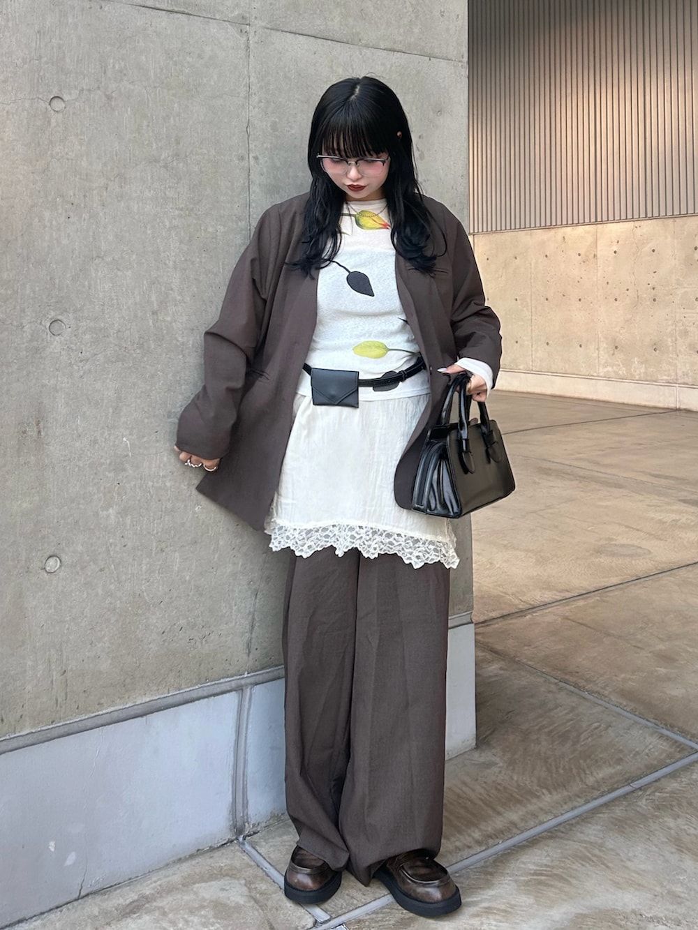 ブラウン系のノーカラージャケット、ブラウン系のその他パンツ、ホワイト系のキャミソールを着用したレディースの冬コーディネートの2枚目の写真