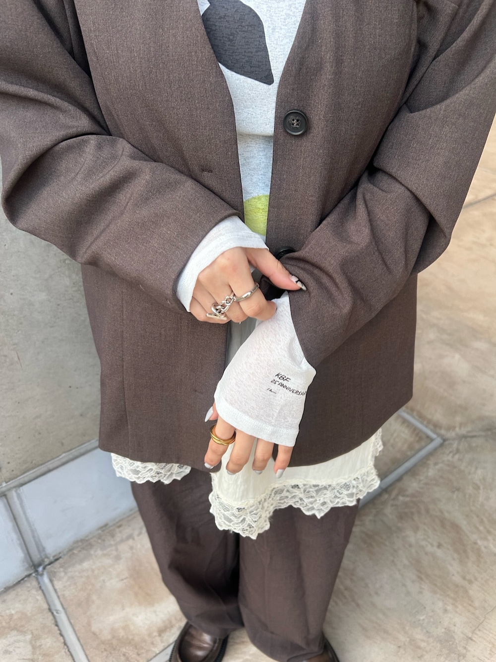 ブラウン系のノーカラージャケット、ブラウン系のその他パンツ、ホワイト系のキャミソールを着用したレディースの冬コーディネートの5枚目の写真