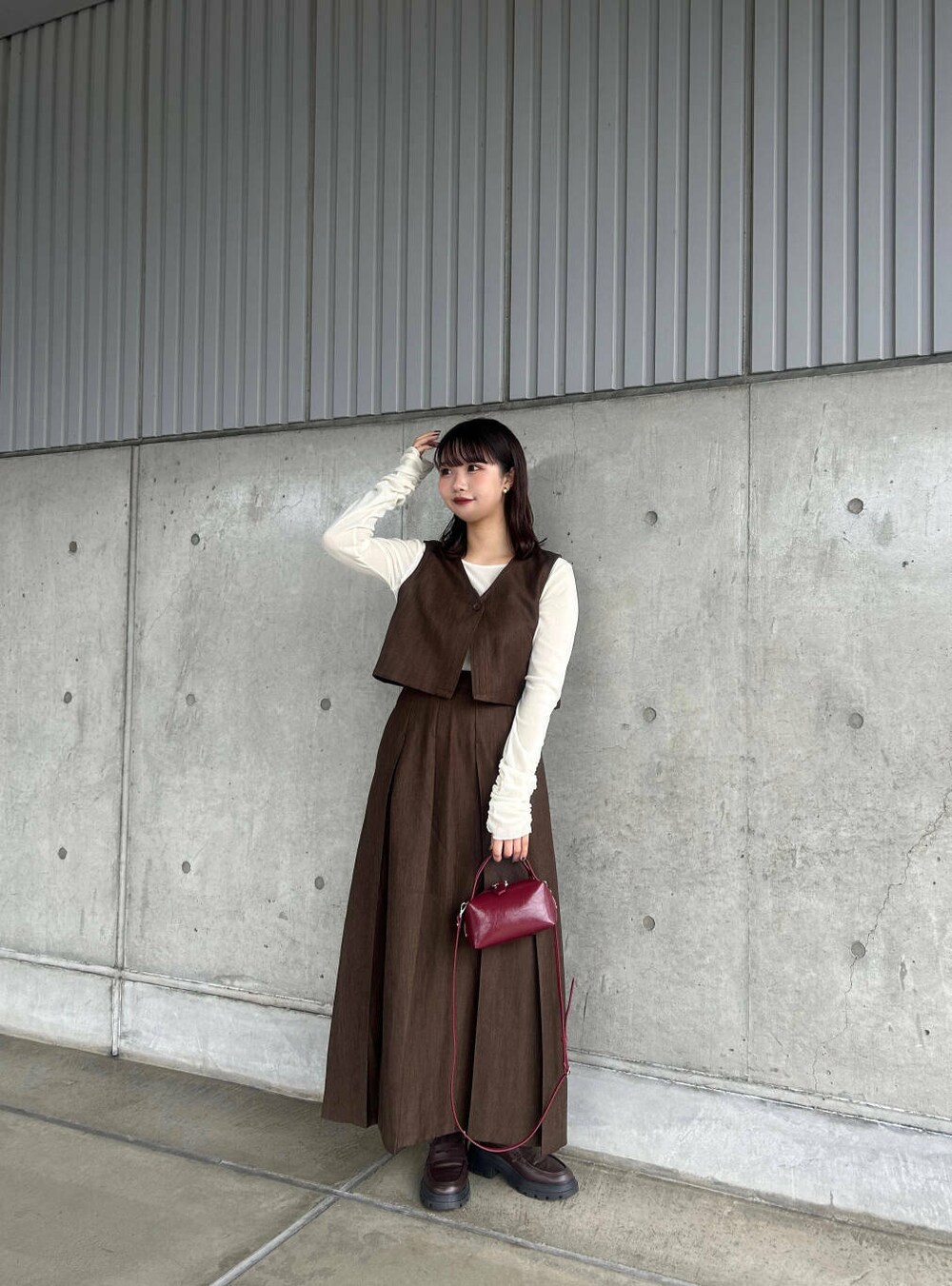 ホワイト系のTシャツ/カットソー、ブラウン系のワンピース、レッド系のハンドバッグを着用したレディースの秋コーディネートの2枚目の写真