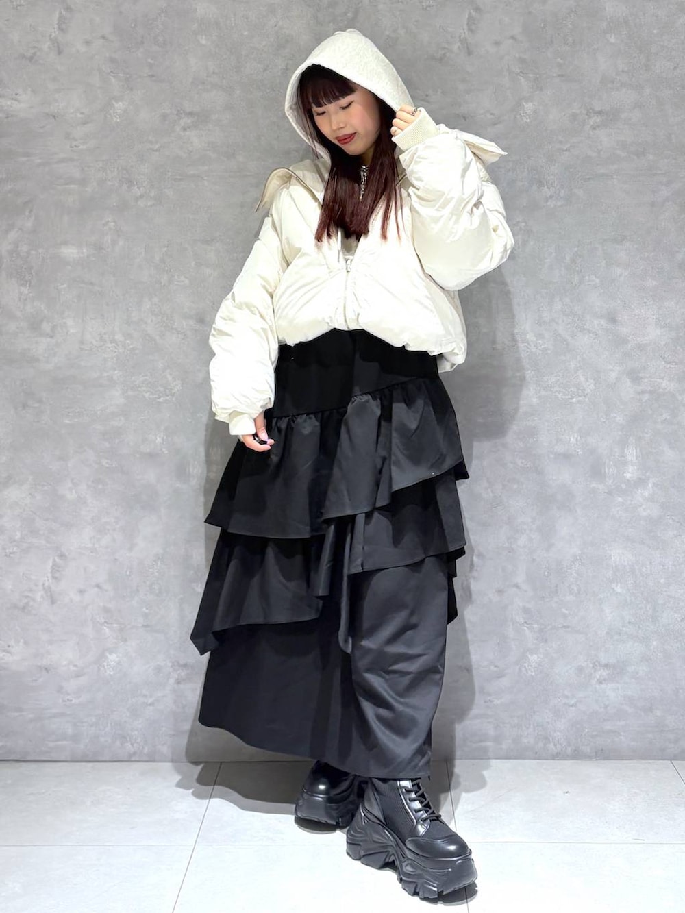 ブラック系のブーツ、ホワイト系のブルゾン、ベージュ系のパーカーを着用したレディースの冬コーディネートの7枚目の写真