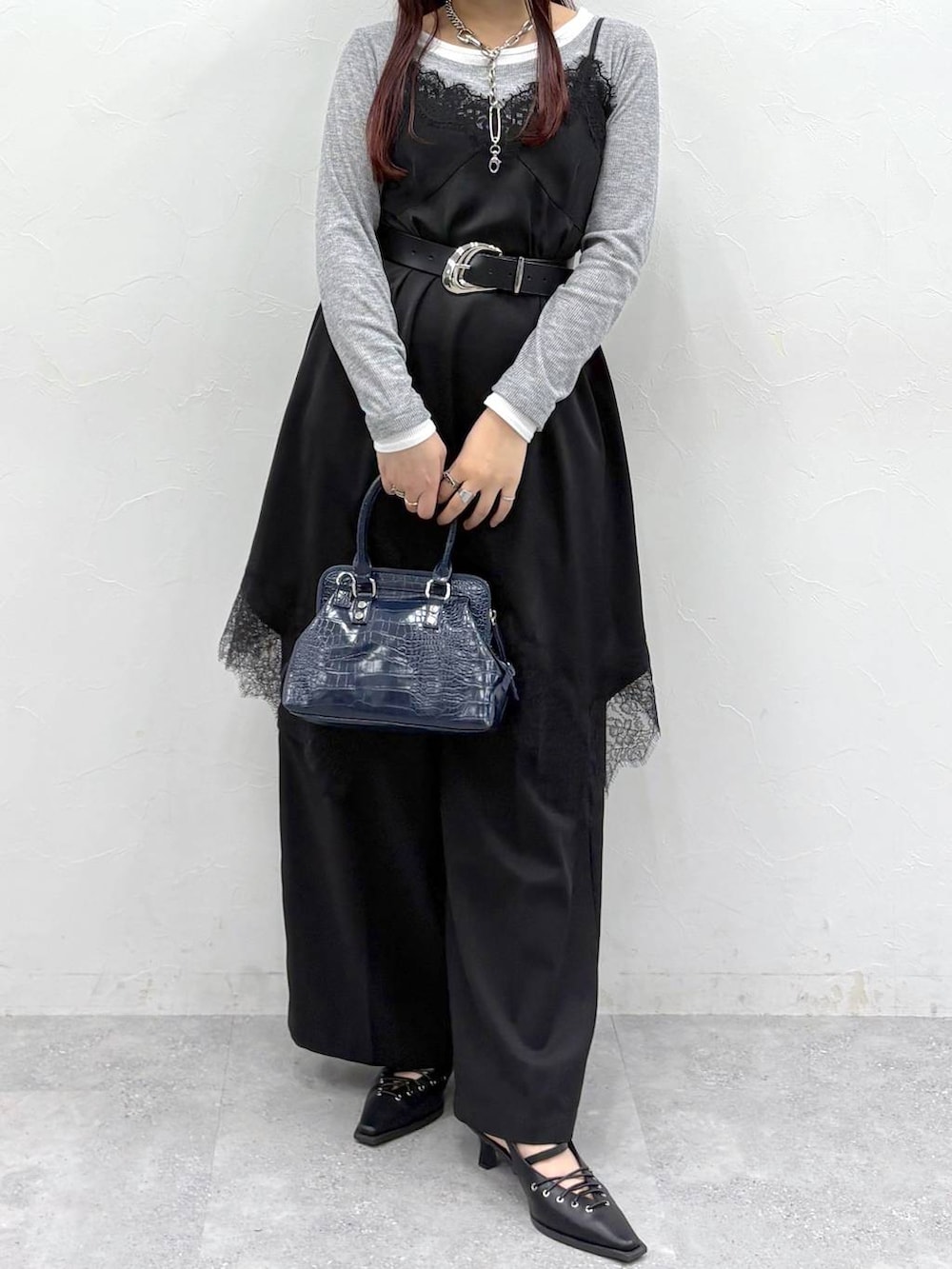 ブルー系のハンドバッグ、ブラック系のスラックス、ブラック系のサンダルを着用したレディースの春コーディネートの3枚目の写真