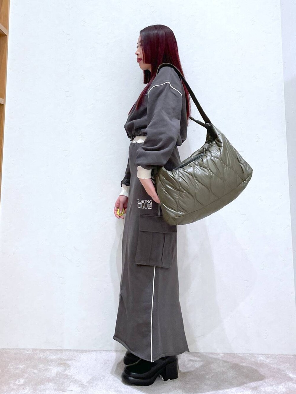 グレー系のスウェット、グレー系のスカート、ブラック系のブーツを着用したレディースの冬コーディネートの5枚目の写真