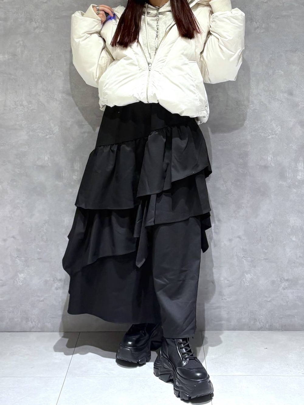 ブラック系のブーツ、ホワイト系のブルゾン、ベージュ系のパーカーを着用したレディースの冬コーディネートの8枚目の写真