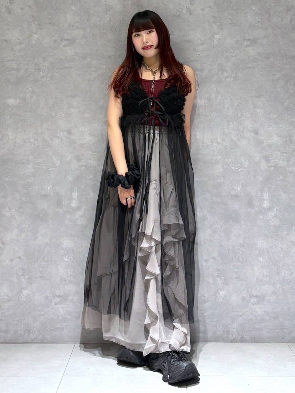 グレー系のスカート、レッド系のタンクトップ、ブラック系のワンピースを着用したレディースの夏コーディネートの7枚目の写真