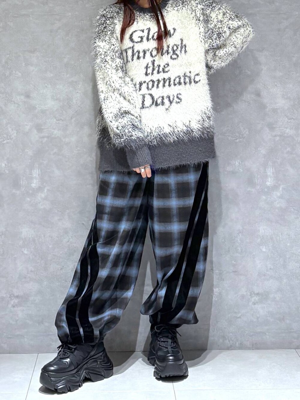 ブラック系のスニーカー、グレー系のニット/セーター、ブラック系のスラックスを着用したレディースの秋コーディネートの6枚目の写真