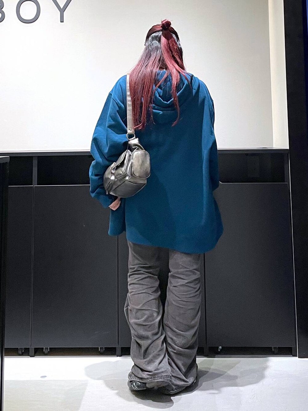 ブラック系のデニムパンツ、その他のショルダーバッグ、ブルー系のパーカーを着用したレディースの秋コーディネートの4枚目の写真