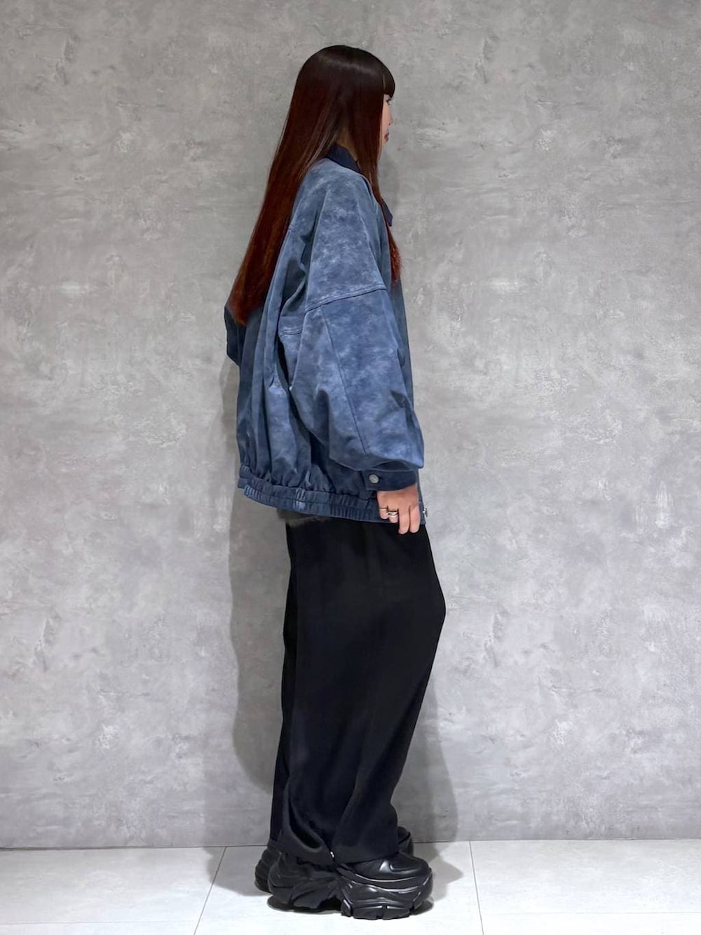 ブラック系のスニーカー、ブルー系のブルゾン、グレー系のニット/セーターを着用したレディースの秋コーディネートの6枚目の写真