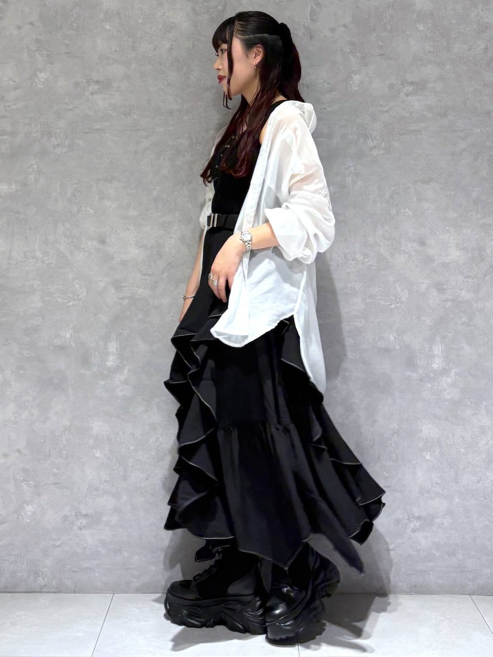 ブラック系のブーツ、ブラック系のスカート、ホワイト系のシャツ/ブラウスを着用したレディースの春コーディネートの3枚目の写真