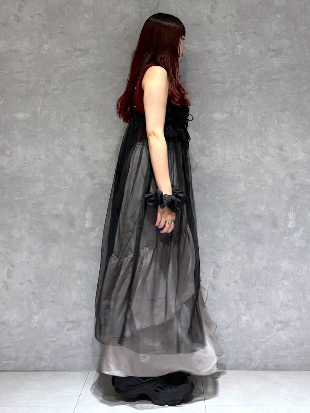 グレー系のスカート、レッド系のタンクトップ、ブラック系のワンピースを着用したレディースの夏コーディネートの6枚目の写真