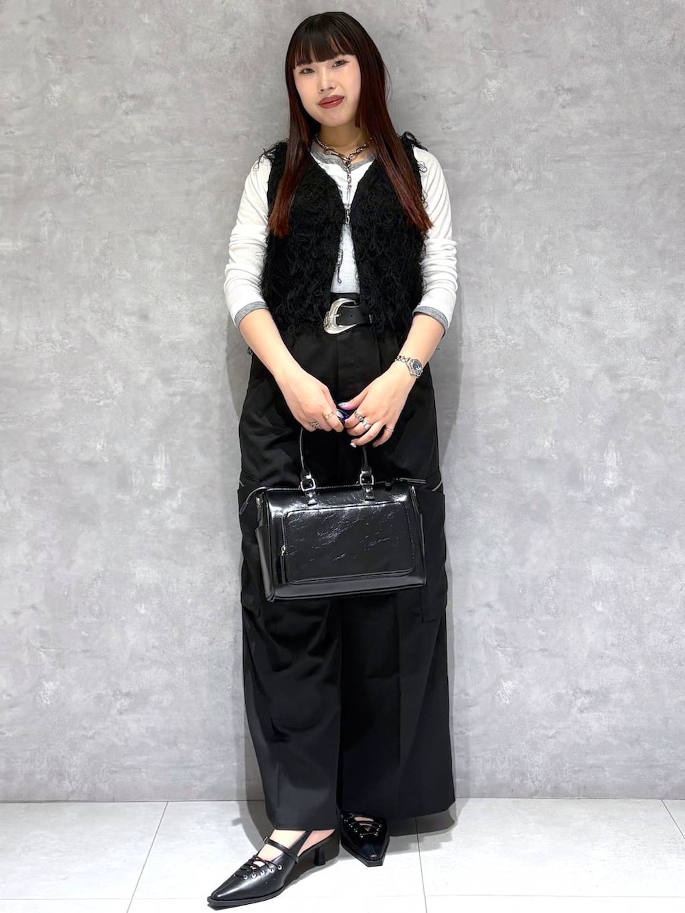 ブラック系のショルダーバッグ、ブラック系のスラックス、ブラック系のサンダルを着用したレディースの春コーディネートの8枚目の写真