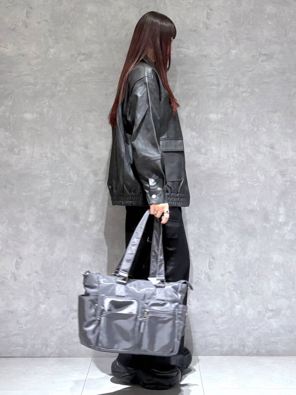 ブラック系のブーツ、グレー系のボストンバッグ、ブラック系のブルゾンを着用したレディースの秋コーディネートの6枚目の写真