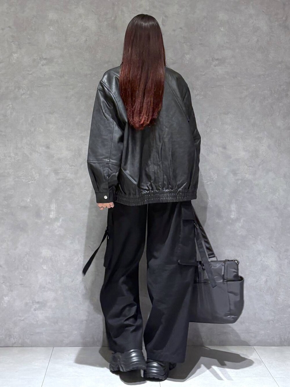 ブラック系のブーツ、グレー系のボストンバッグ、ブラック系のブルゾンを着用したレディースの秋コーディネートの5枚目の写真