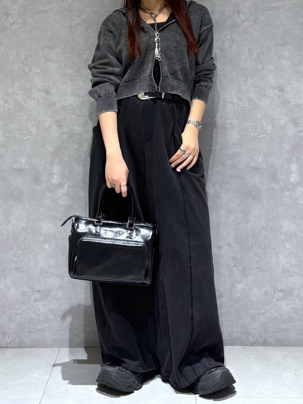 ブラック系のスウェットパンツ、ブラック系のショルダーバッグ、グレー系のパーカーを着用したレディースの冬コーディネートの2枚目の写真