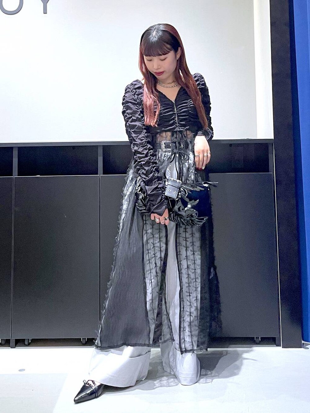 ブラック系のパンプス、ブラック系のショルダーバッグ、ブラック系のワンピースを着用したレディースの夏コーディネートの2枚目の写真