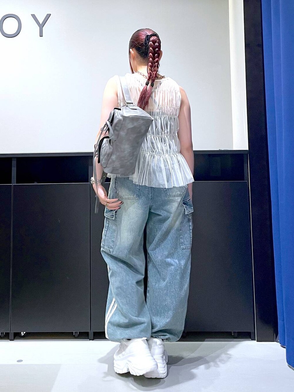 ホワイト系のスニーカー、ブルー系のデニムパンツ、グレー系のショルダーバッグを着用したレディースの夏コーディネートの6枚目の写真