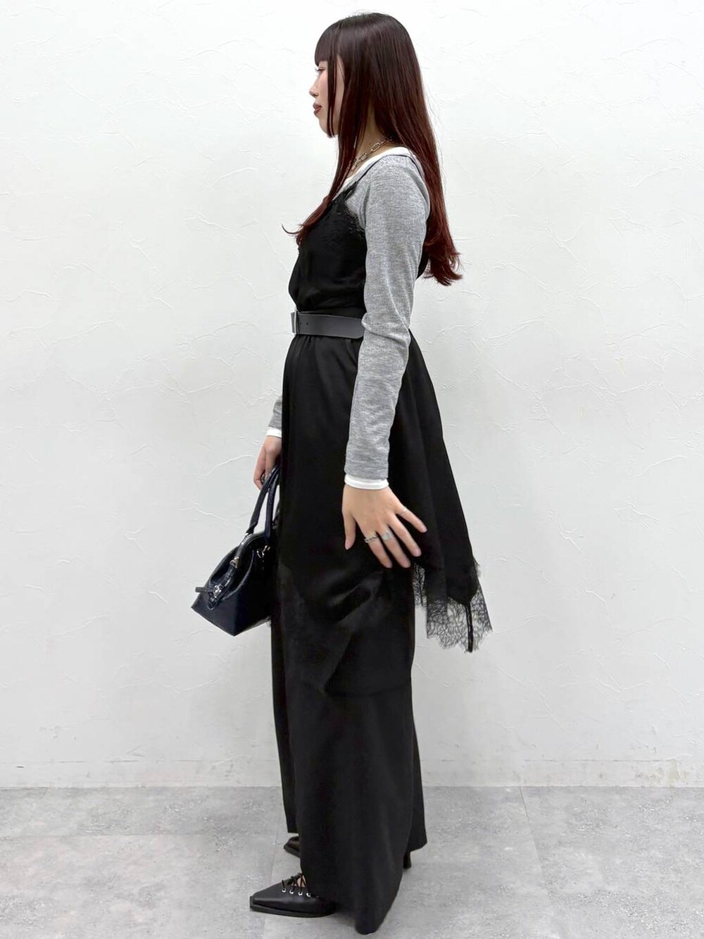 ブルー系のハンドバッグ、ブラック系のスラックス、ブラック系のサンダルを着用したレディースの春コーディネートの5枚目の写真