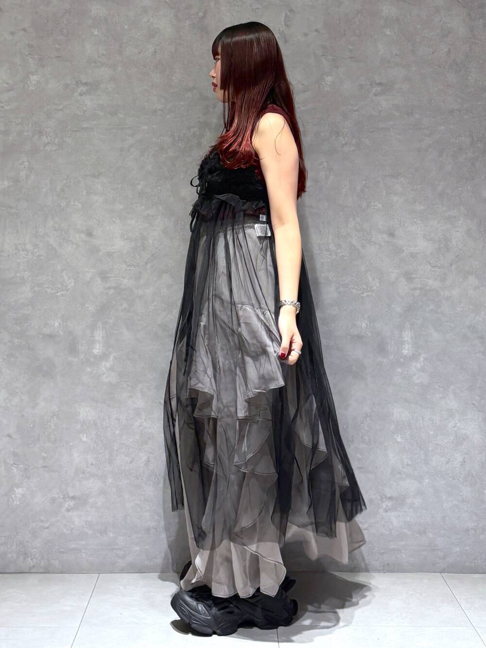 グレー系のスカート、レッド系のタンクトップ、ブラック系のワンピースを着用したレディースの夏コーディネートの4枚目の写真