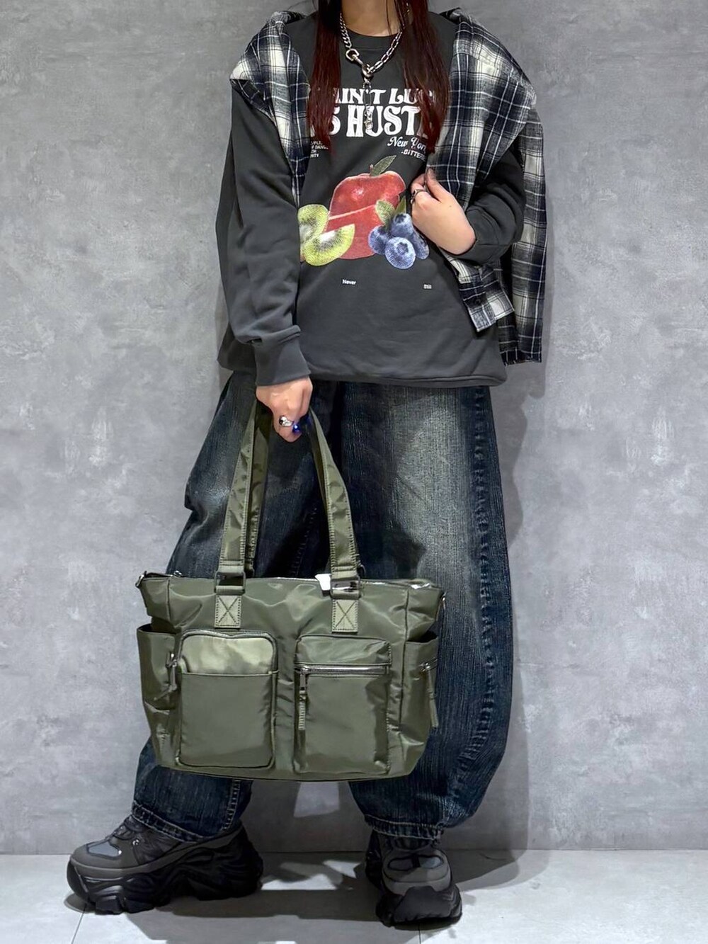 ブラック系のスニーカー、グリーン系のボストンバッグ、ブラック系のスウェットを着用したレディースの秋コーディネートの9枚目の写真