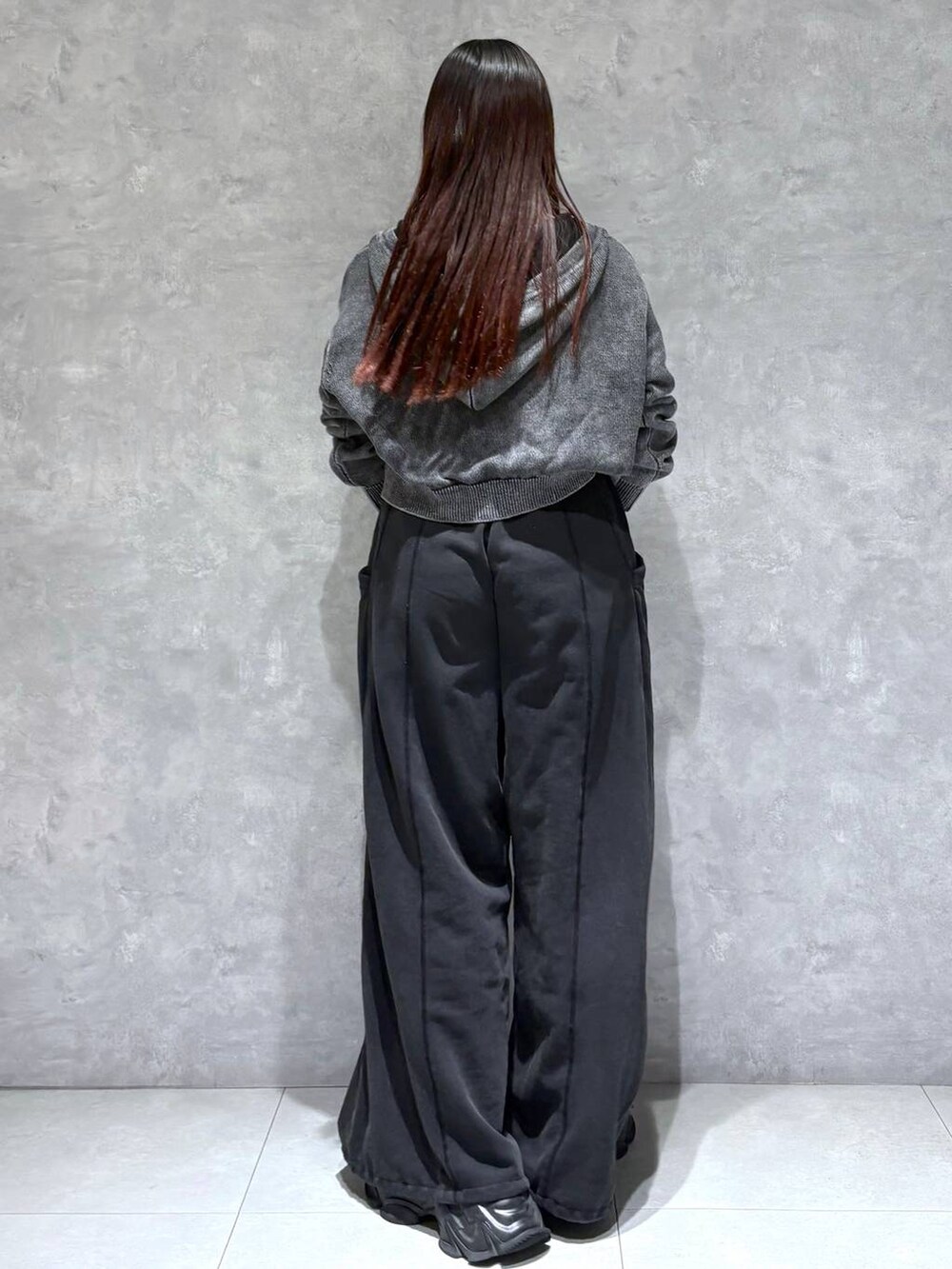 ブラック系のスウェットパンツ、ブラック系のショルダーバッグ、グレー系のパーカーを着用したレディースの冬コーディネートの5枚目の写真