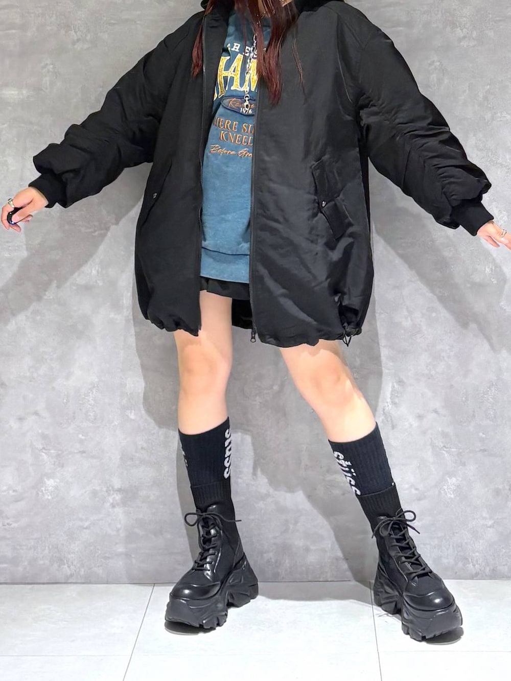 ブラック系のブーツ、グリーン系のスウェット、ブラック系のブルゾンを着用したレディースの冬コーディネートの3枚目の写真