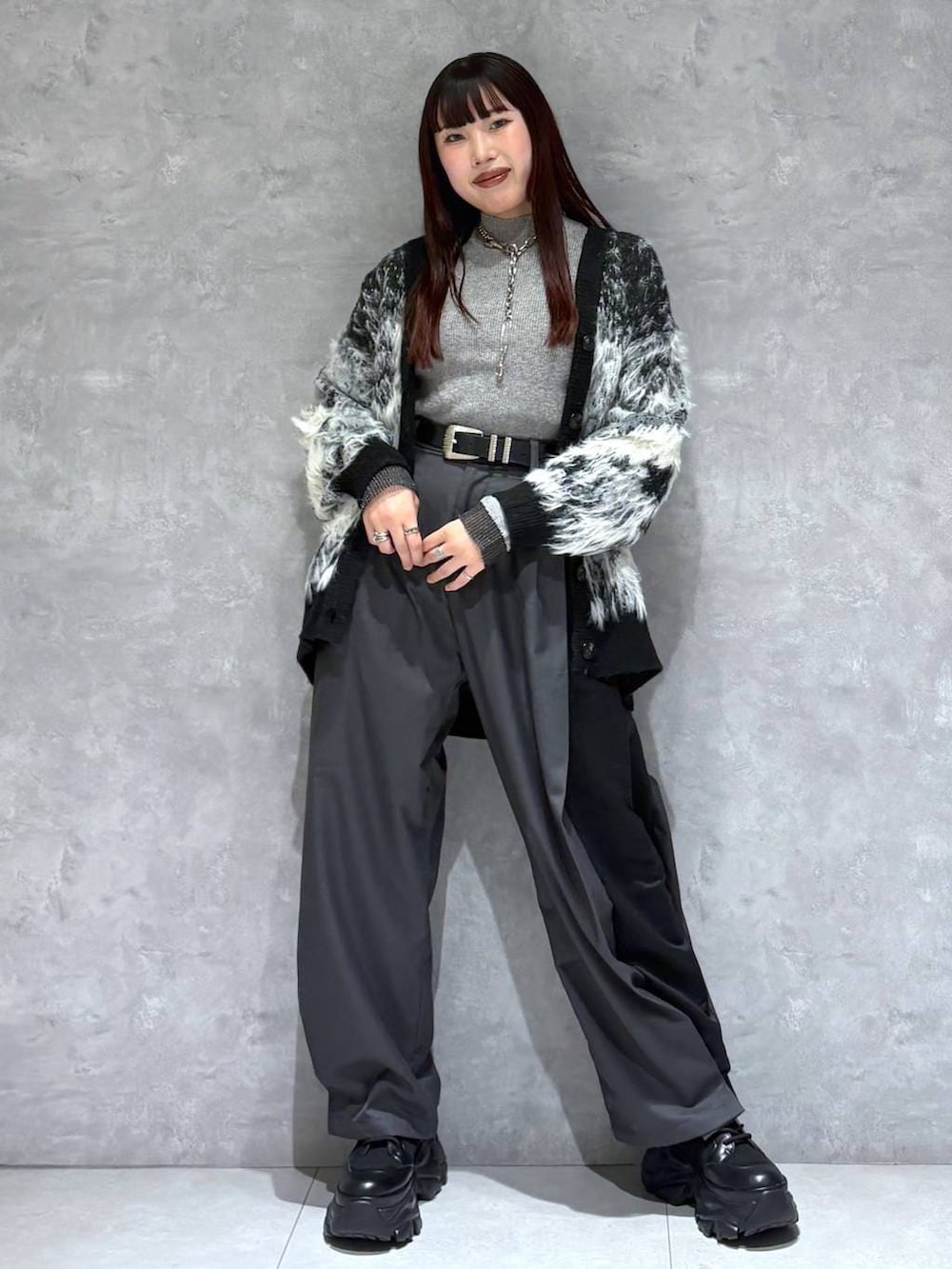 ブラック系のブーツ、ブラック系のカーディガン/ボレロ、グレー系のニット/セーターを着用したレディースの冬コーディネートの2枚目の写真