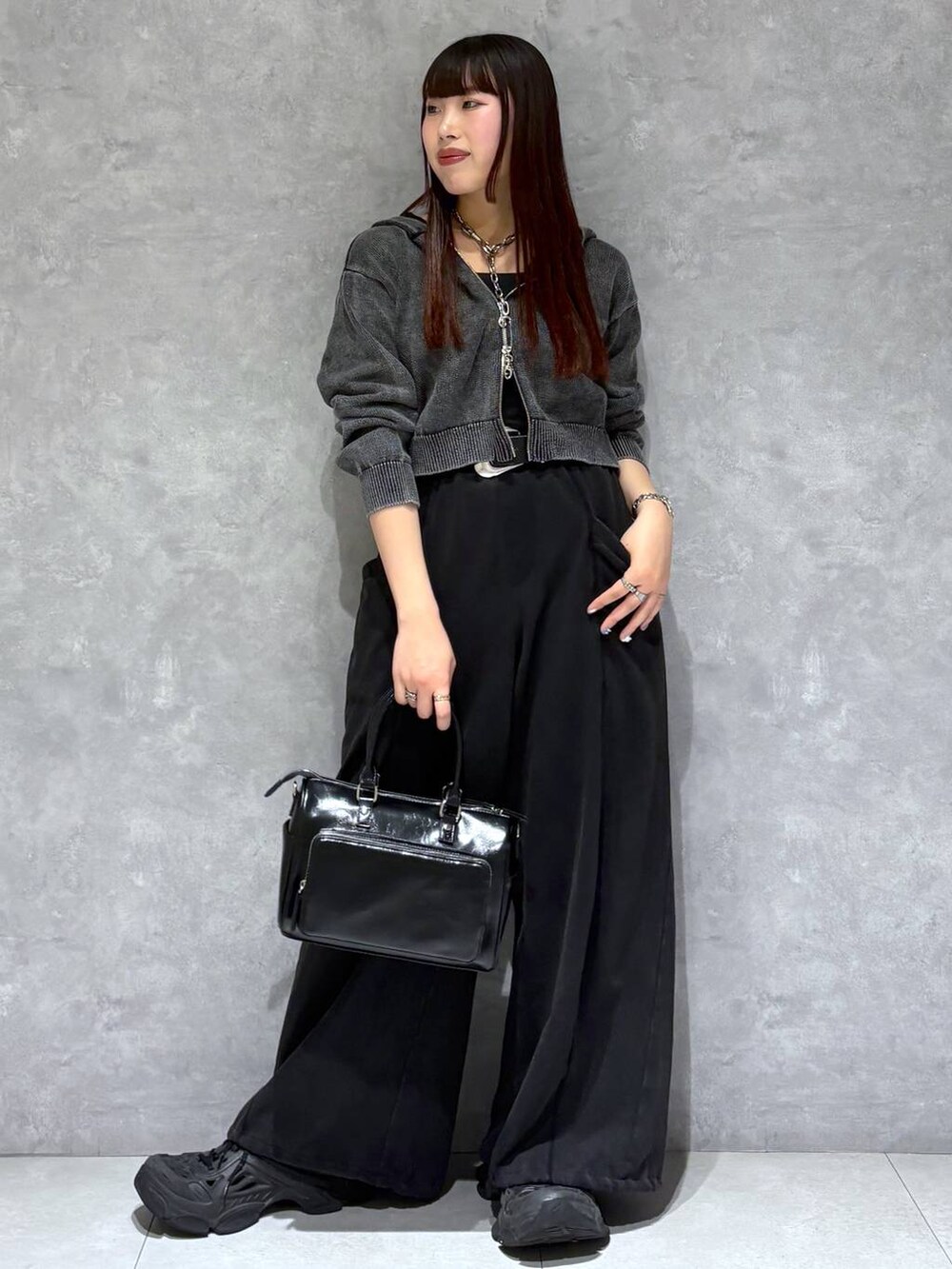 ブラック系のスウェットパンツ、ブラック系のショルダーバッグ、グレー系のパーカーを着用したレディースの冬コーディネートの9枚目の写真