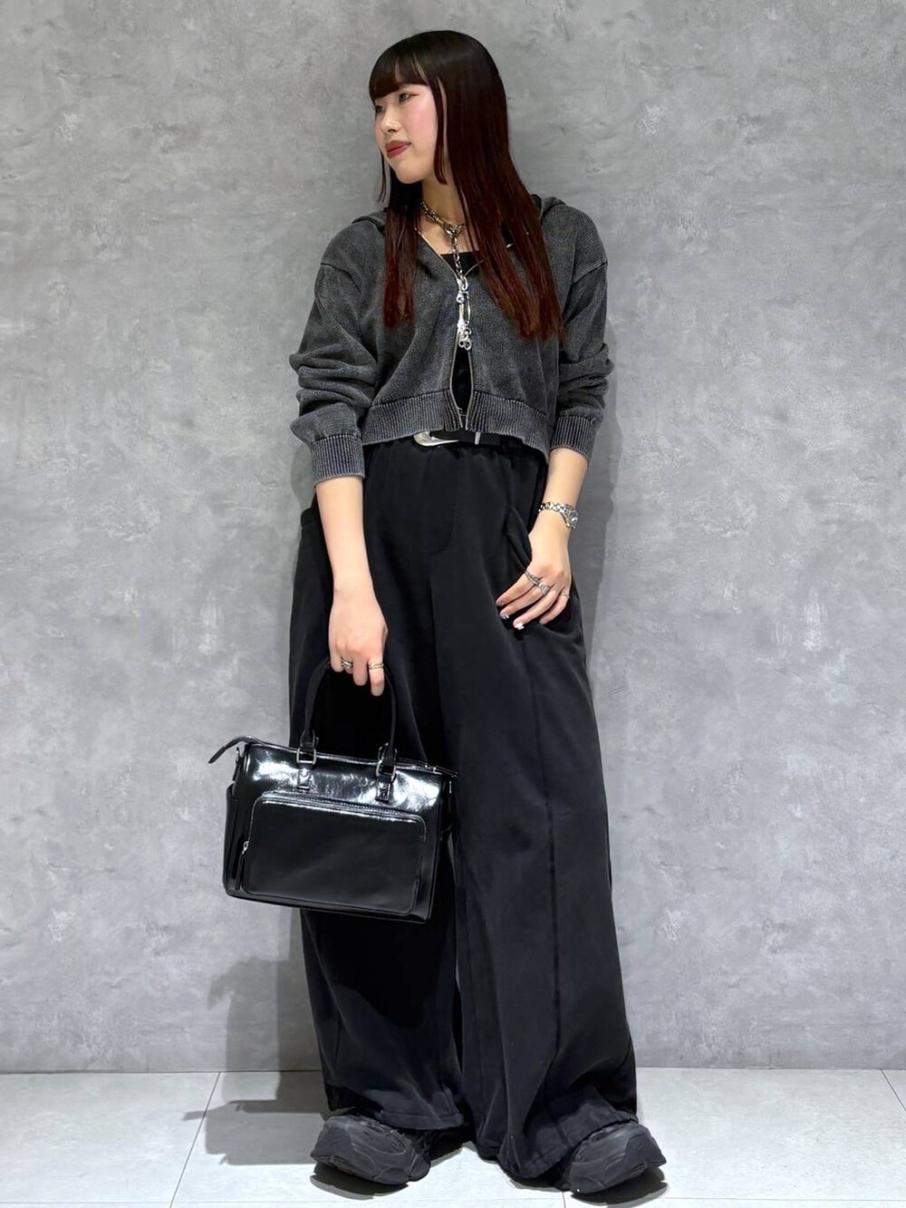 ブラック系のスウェットパンツ、ブラック系のショルダーバッグ、グレー系のパーカーを着用したレディースの冬コーディネートの3枚目の写真