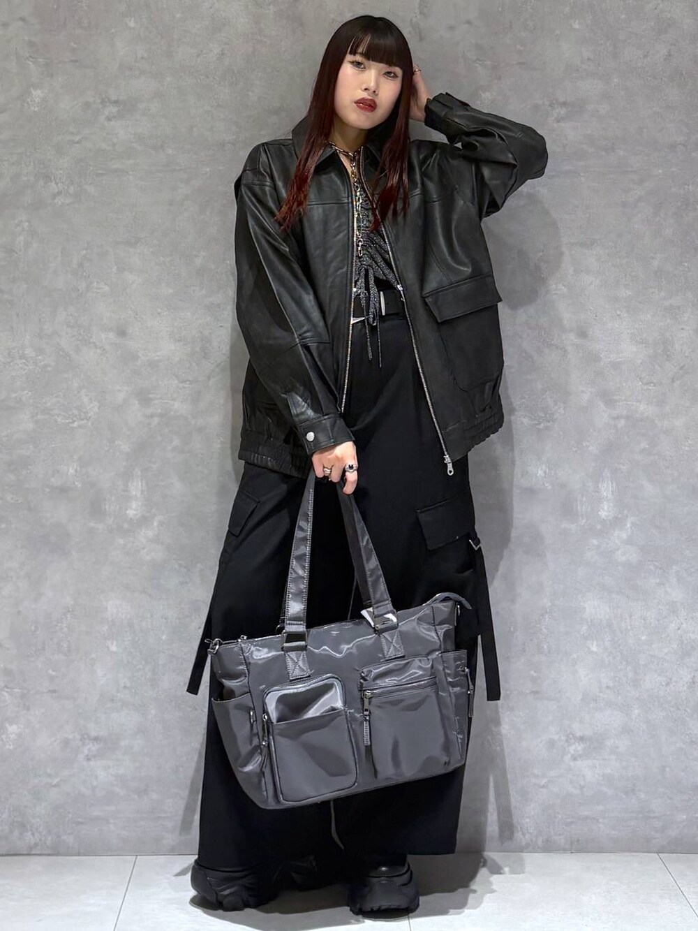 ブラック系のブーツ、グレー系のボストンバッグ、ブラック系のブルゾンを着用したレディースの秋コーディネートの3枚目の写真