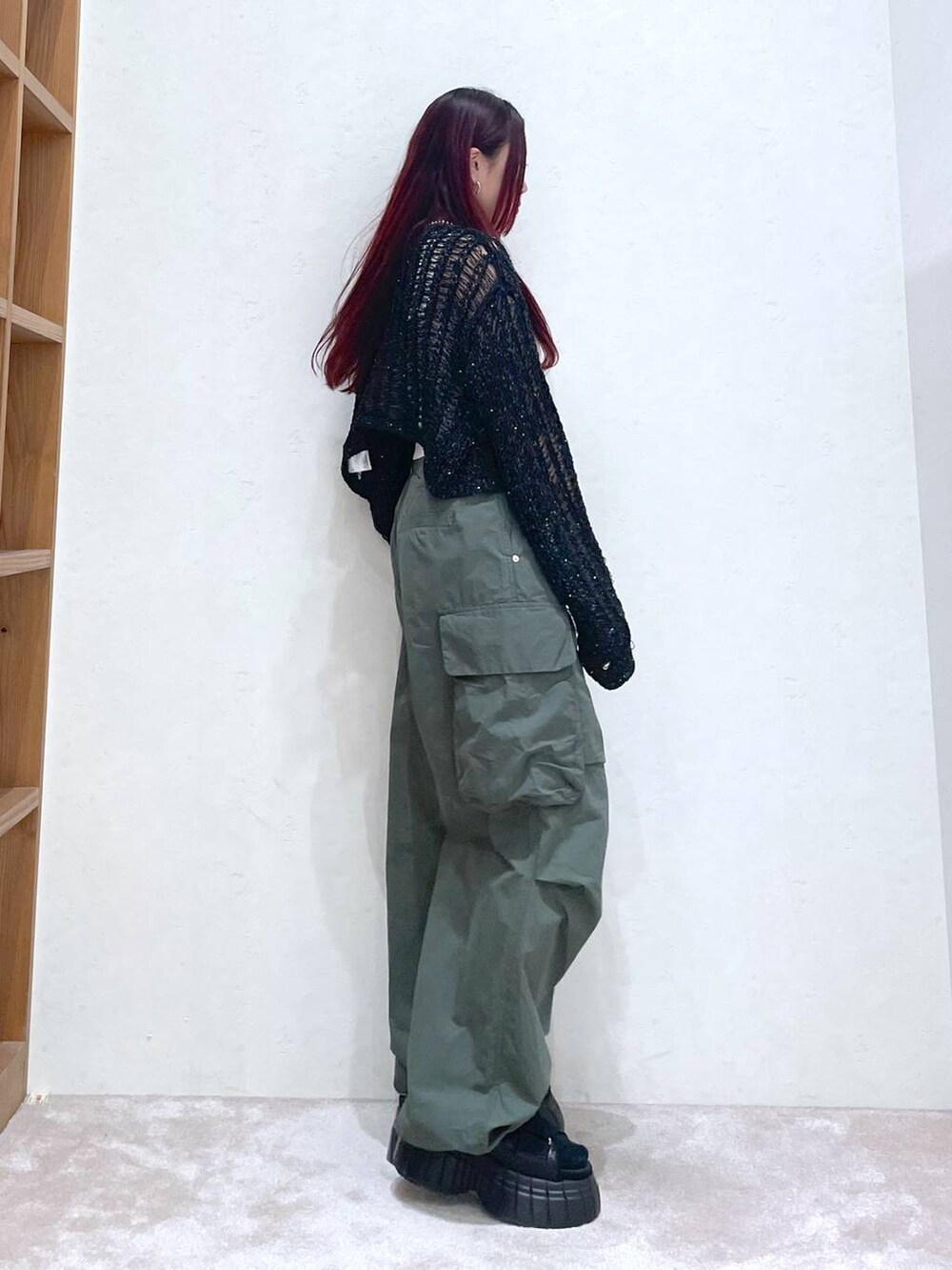 ブラック系のスニーカー、グリーン系のカーゴパンツ、ホワイト系のタンクトップを着用したレディースの春コーディネートの6枚目の写真