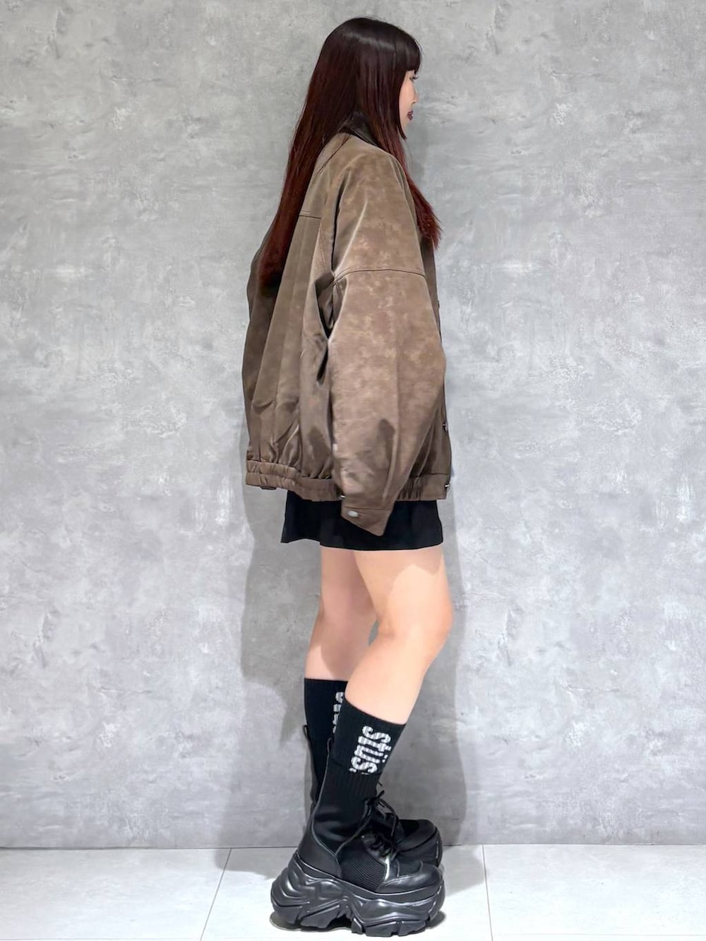 ブラック系のブーツ、ブラック系のその他パンツ、ブラウン系のブルゾンを着用したレディースの秋コーディネートの6枚目の写真