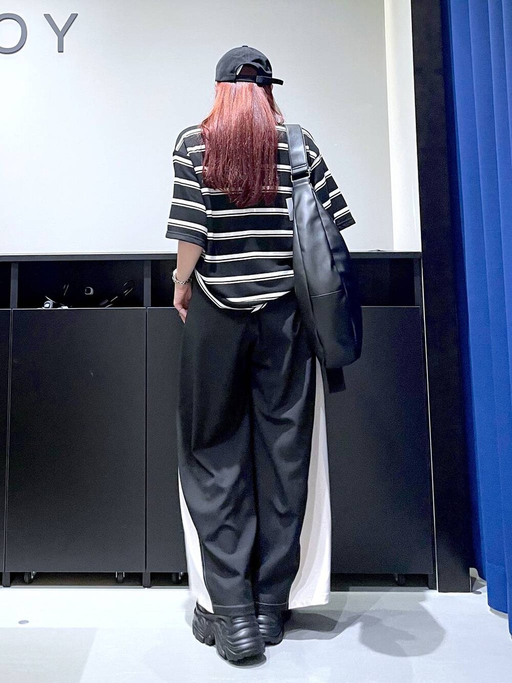 ブラック系のスニーカー、グレー系のその他パンツ、ブラック系のTシャツ/カットソーを着用したレディースの秋コーディネートの4枚目の写真