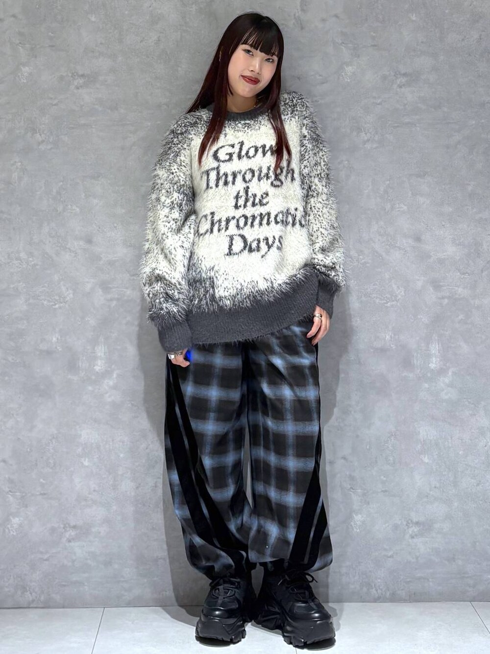 ブラック系のスニーカー、グレー系のニット/セーター、ブラック系のスラックスを着用したレディースの秋コーディネートの3枚目の写真