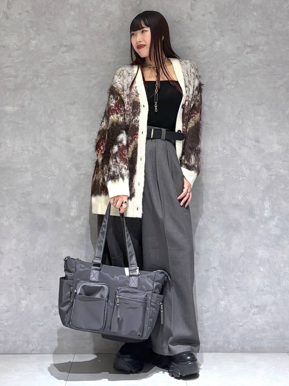 ブラック系のブーツ、グレー系のボストンバッグ、ホワイト系のカーディガン/ボレロを着用したレディースの秋コーディネートの9枚目の写真
