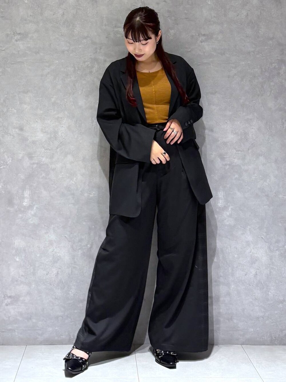 ブラック系のパンプス、ブラック系のテーラードジャケット、グレー系のスラックスを着用したレディースの秋コーディネートの9枚目の写真